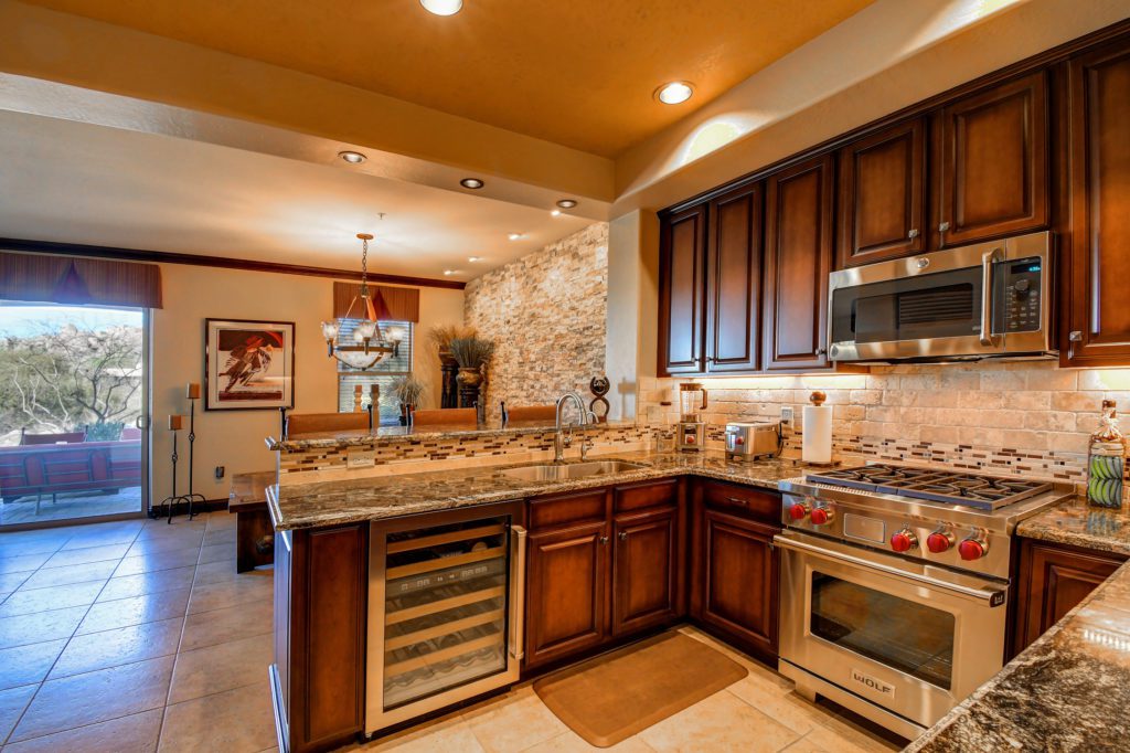 A kitchen with wooden cabinets and granite counter tops.