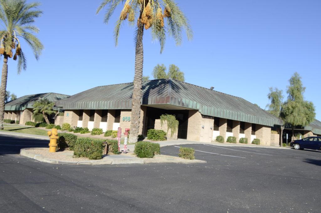 A large building with palm trees in front of it.
