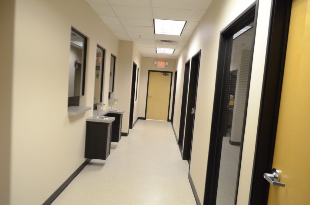 A hallway with two sinks and mirrors in it.