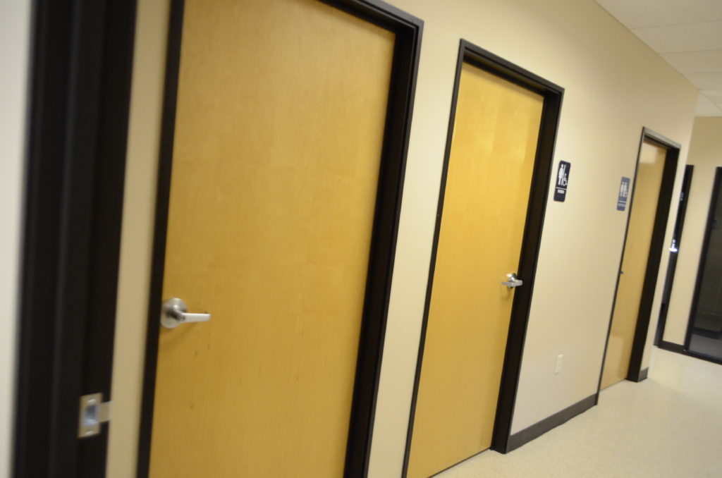 Two doors in a room with yellow walls.