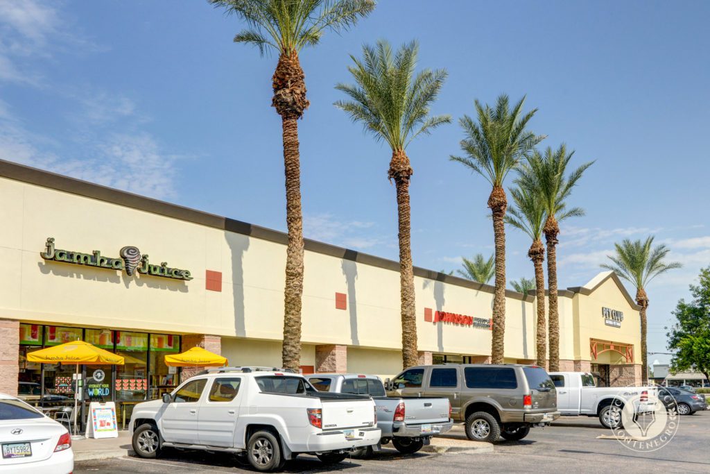 A parking lot with several cars parked in front of it.