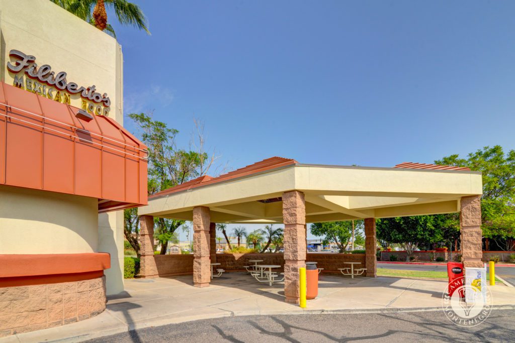A large covered area with picnic tables and umbrellas.