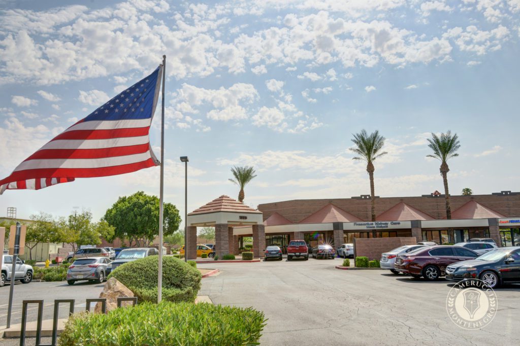 A large american flag in front of a building.