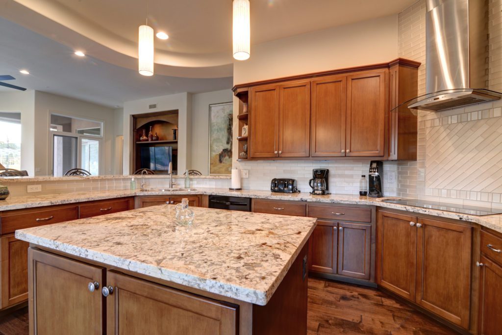 A kitchen with a large island and wooden cabinets.