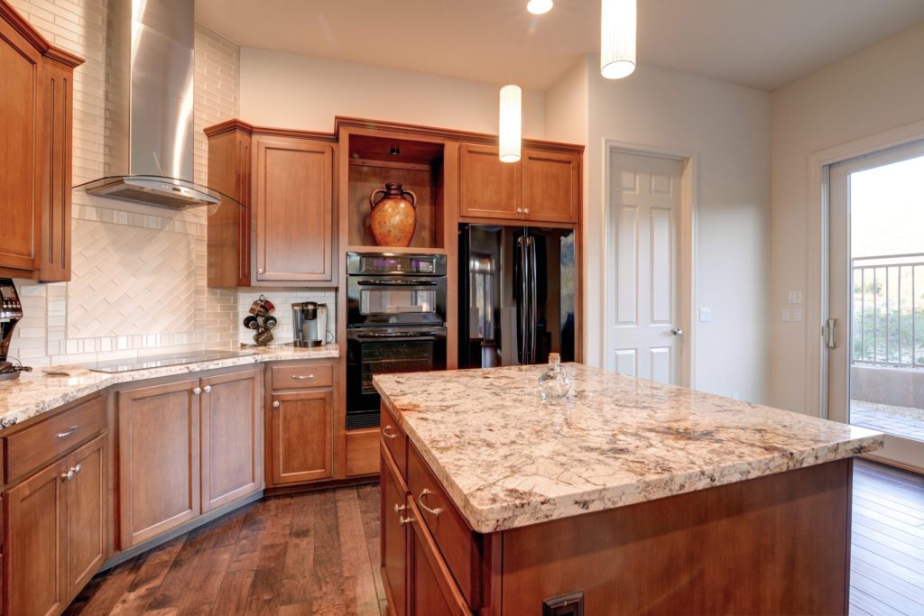 A kitchen with wooden cabinets and granite counter tops.