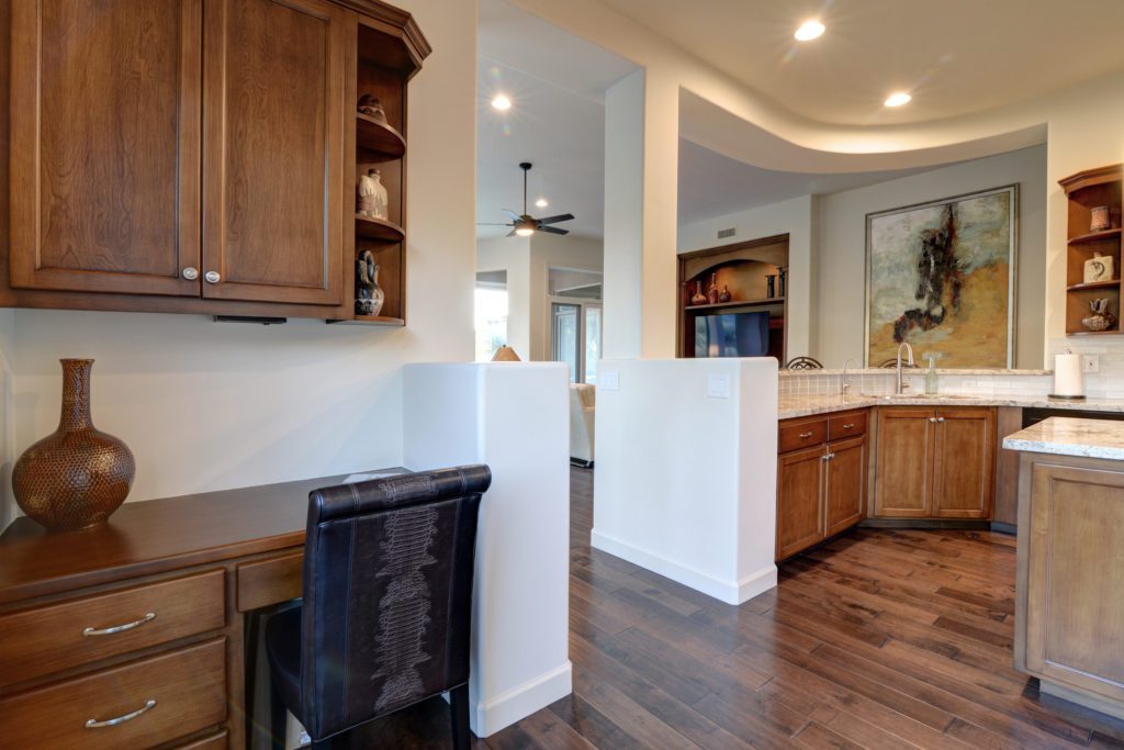 A kitchen with wood floors and white walls.