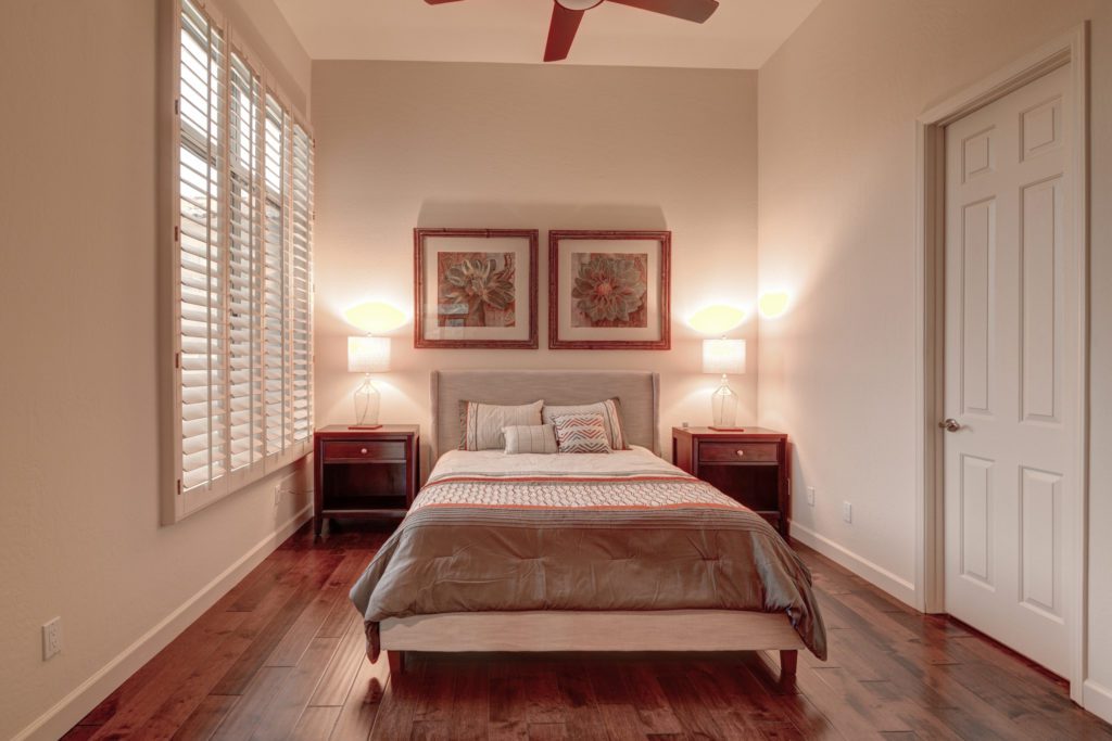 A bedroom with two lamps and a bed