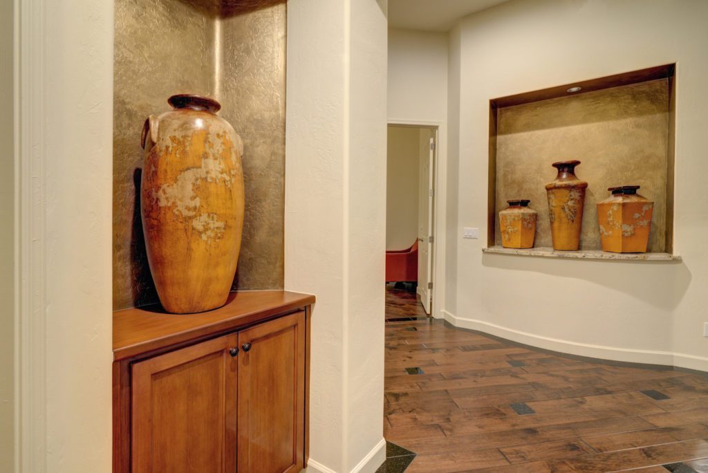 A vase sitting on top of a wooden cabinet.