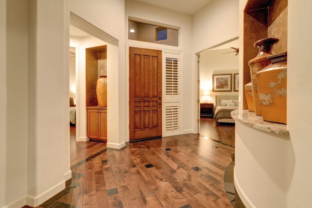 A large room with wooden floors and a door.