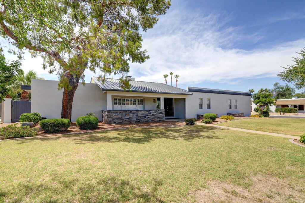 A large white building with a tree in front of it.