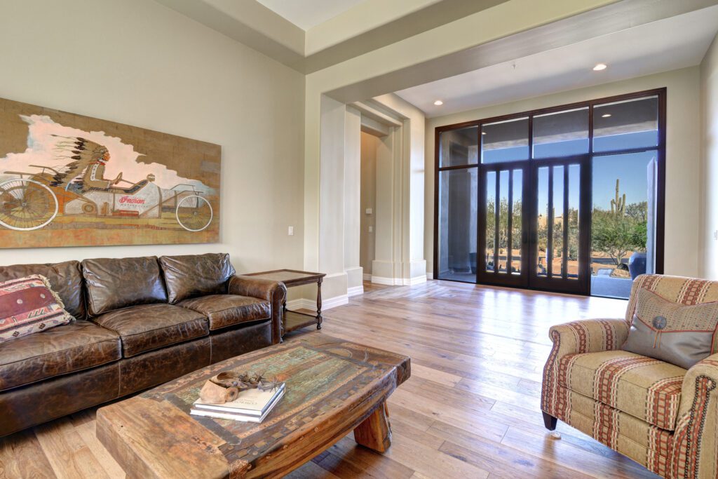 A living room with wood floors and leather furniture.