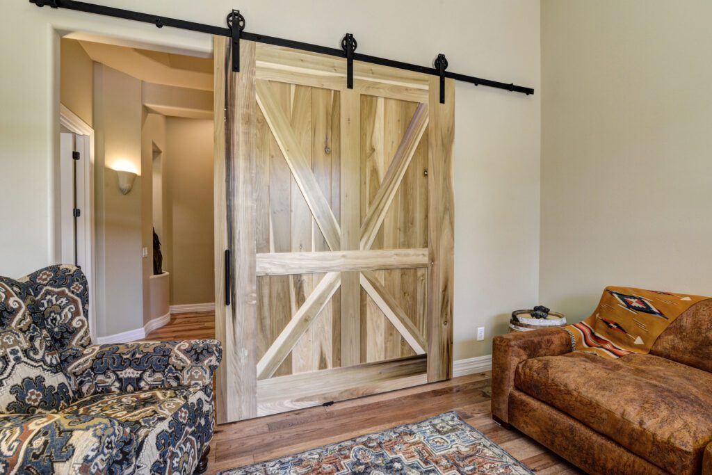 A living room with a couch and a sliding barn door.