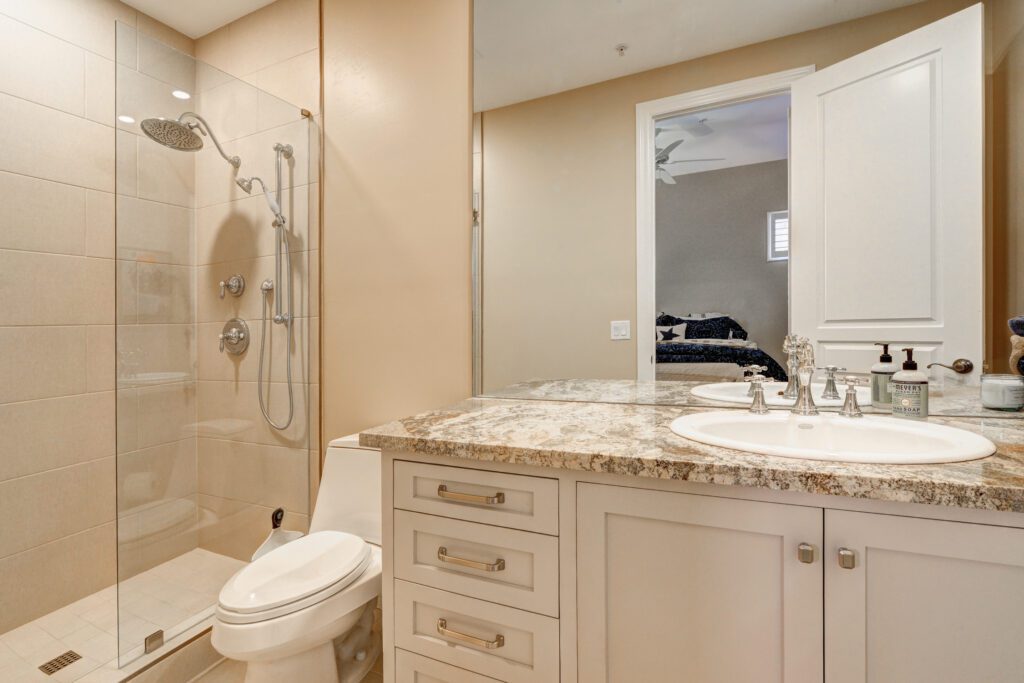 A bathroom with a toilet, sink and mirror.