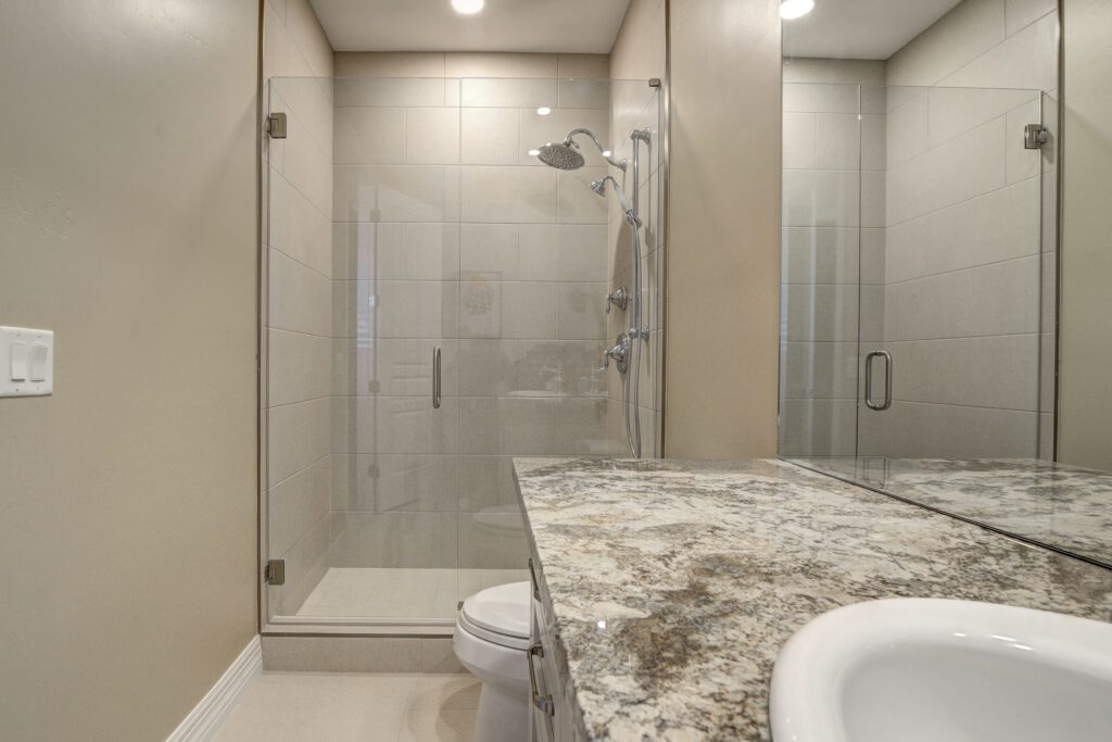 A bathroom with a toilet, sink and shower.