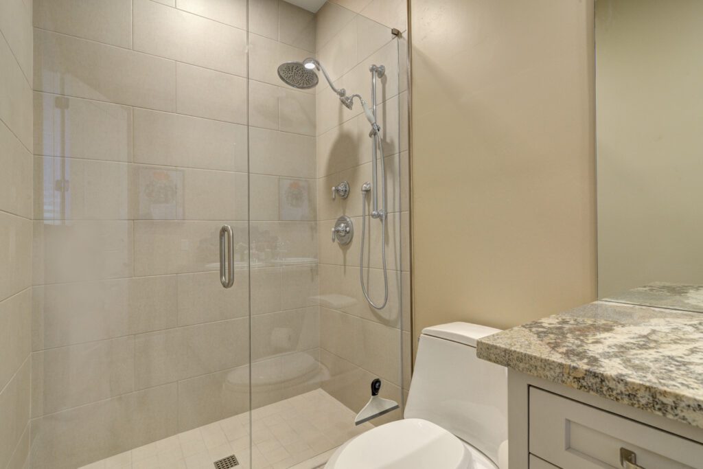 A bathroom with a toilet, shower and sink.
