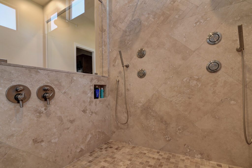 A bathroom with a shower and tiled walls.