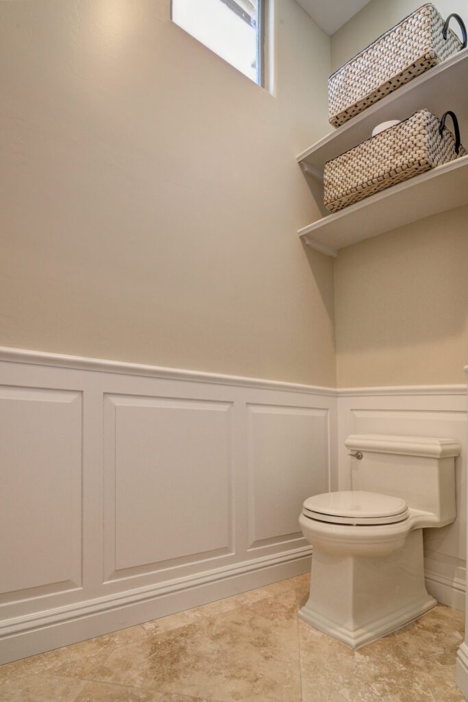 A white toilet sitting in the corner of a bathroom.