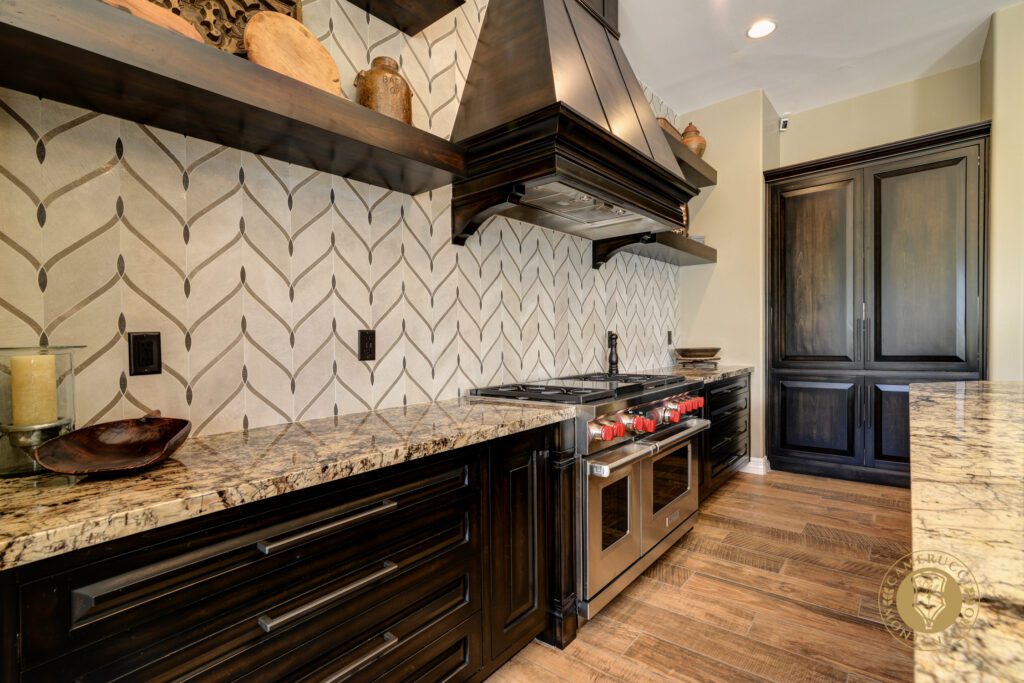 A kitchen with wood floors and black cabinets.