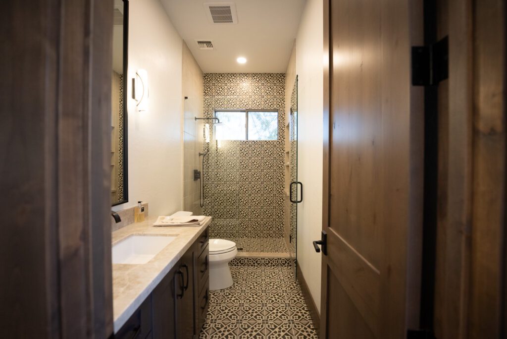 A bathroom with a toilet, sink and shower.