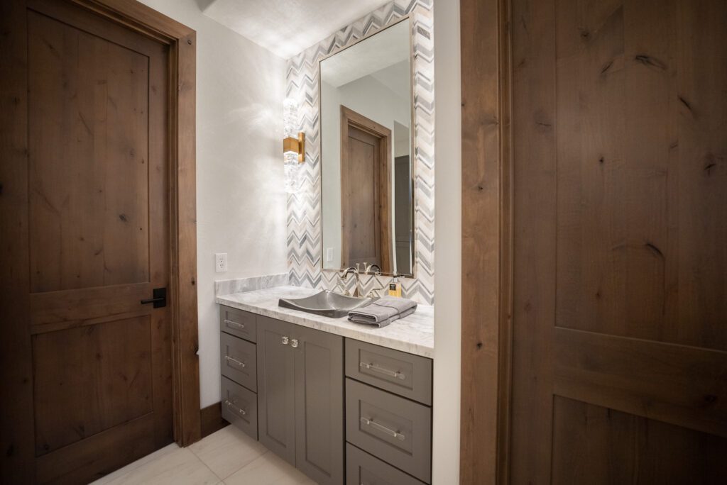 A bathroom with a sink, mirror and lights.