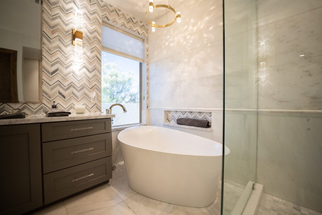 A bathroom with a tub, sink and shower.