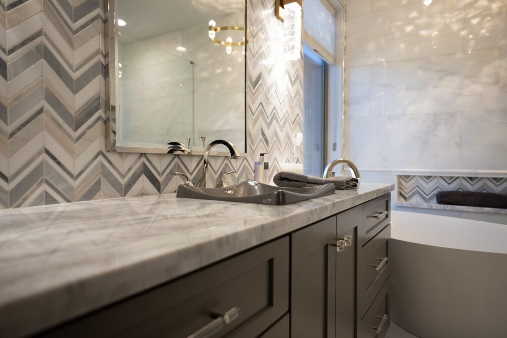 A bathroom with marble counter tops and a large mirror.