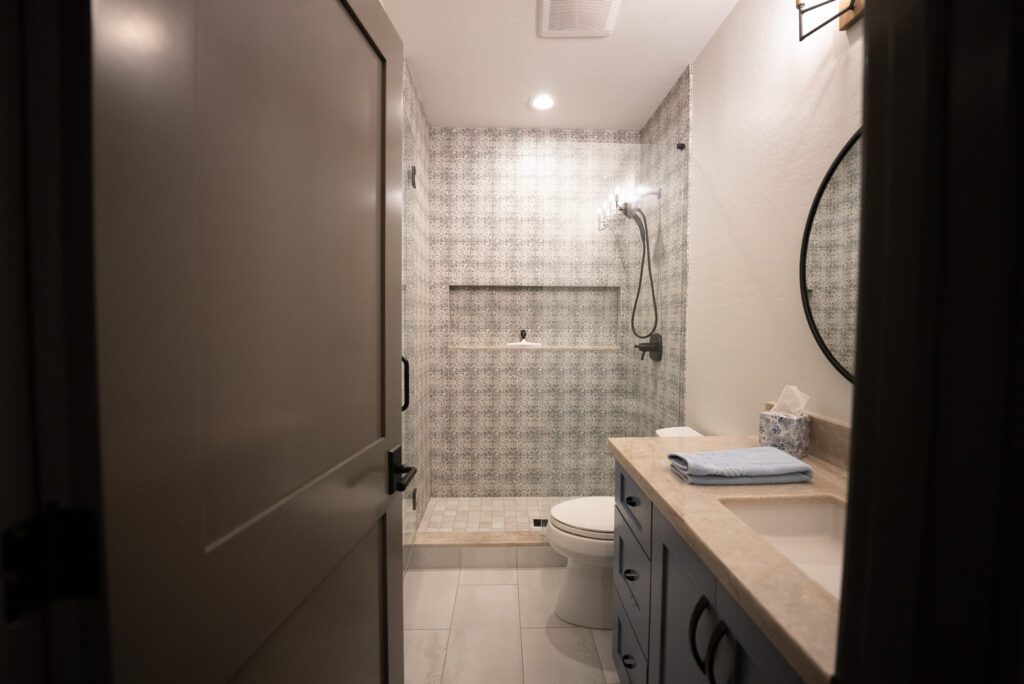A bathroom with a toilet, sink and mirror.