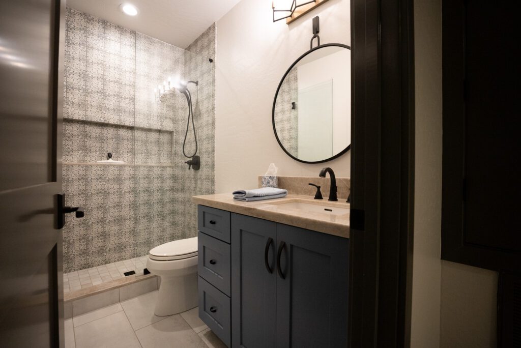 A bathroom with a toilet, sink and mirror.