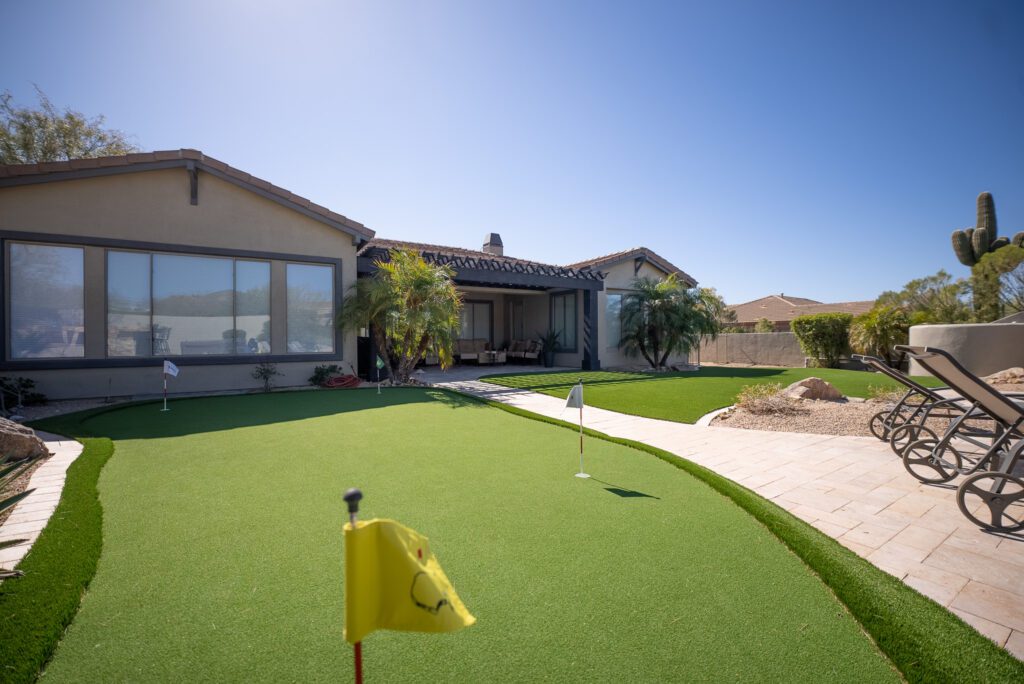 A yard with a golf course and a house