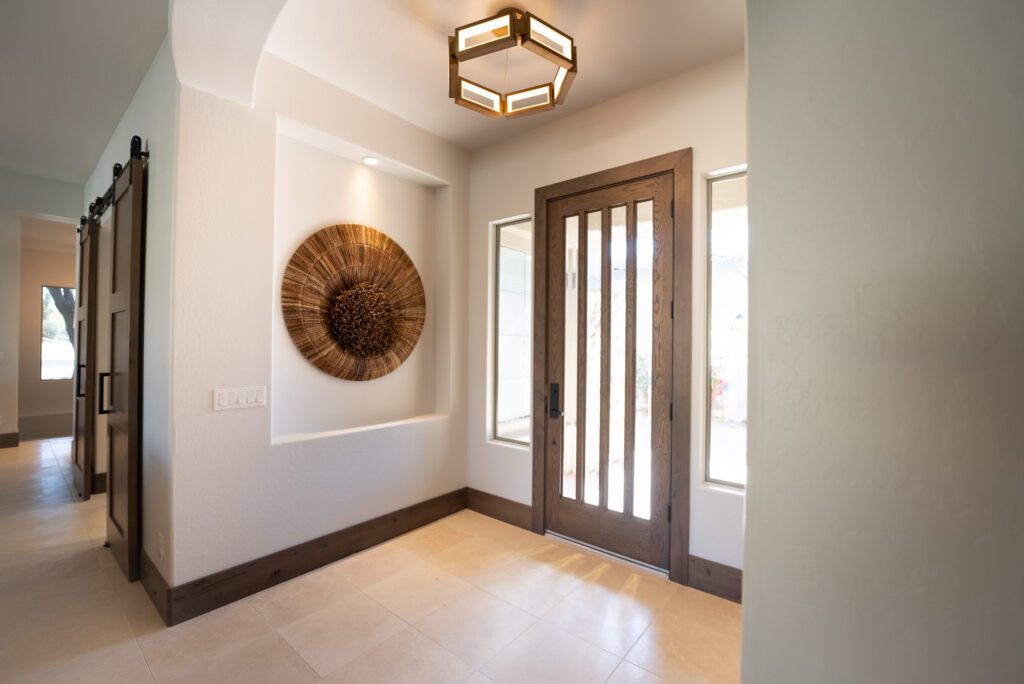 A foyer with a large window and a wooden door.