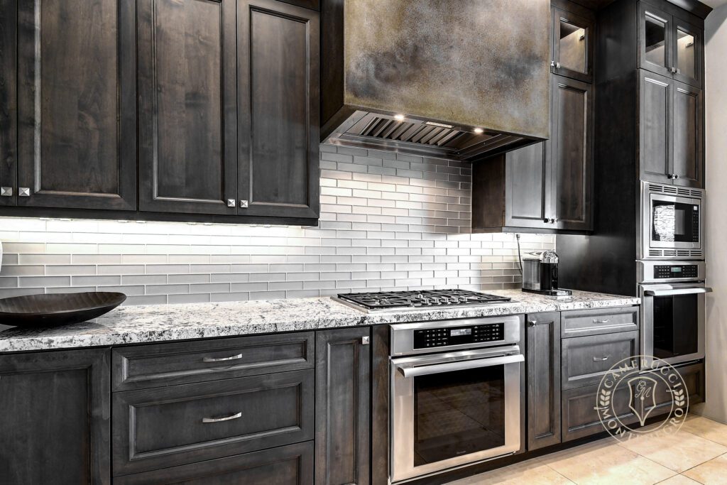 A kitchen with dark wood cabinets and granite countertops.