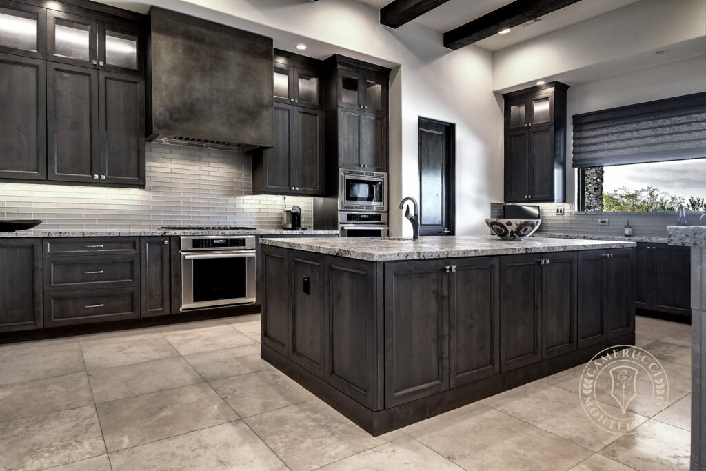 A kitchen with dark cabinets and white counters