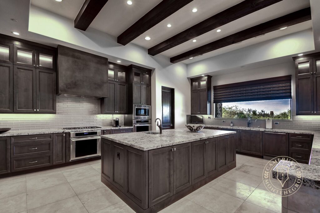 A kitchen with a large island and granite counter tops.