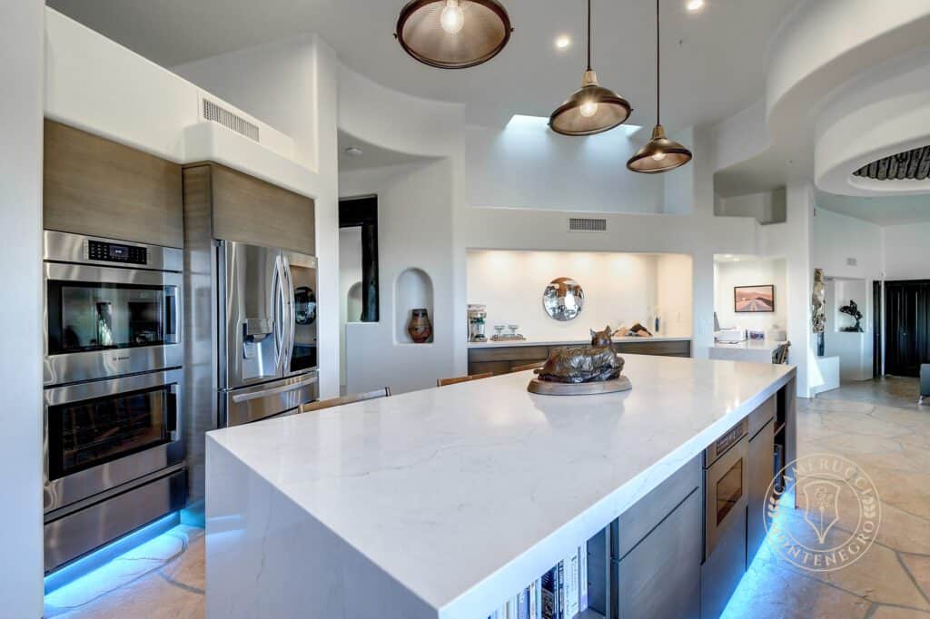 A kitchen with a large island and white cabinets.