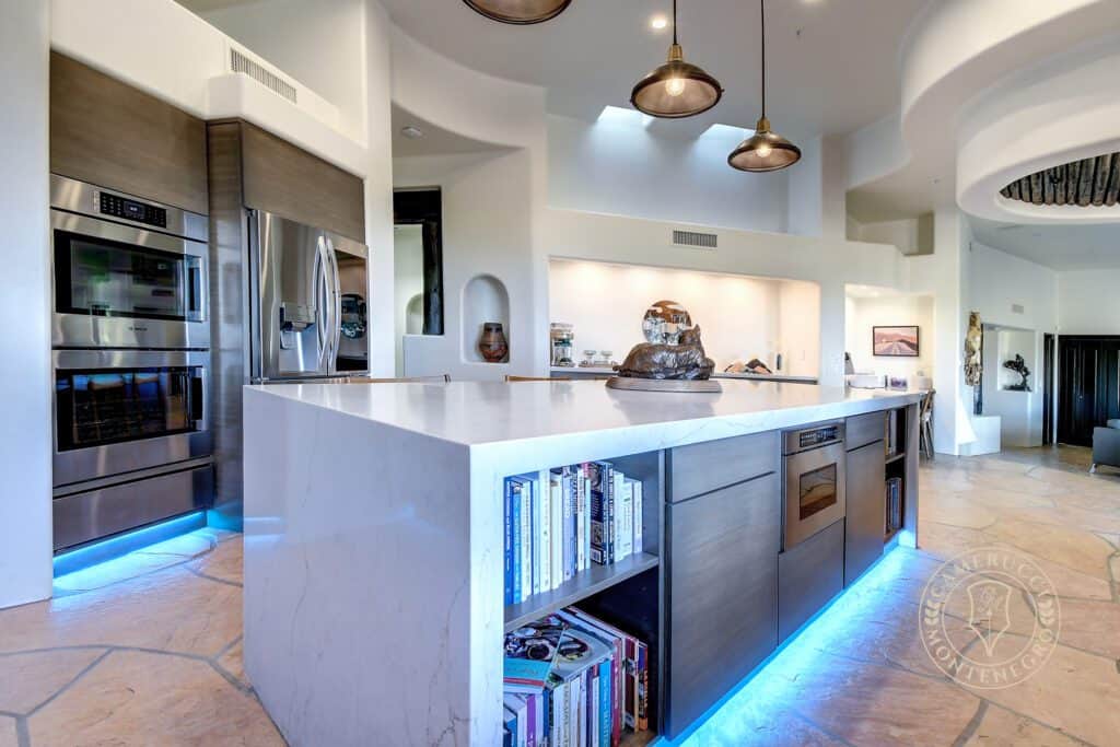 A kitchen with a large island and white cabinets.
