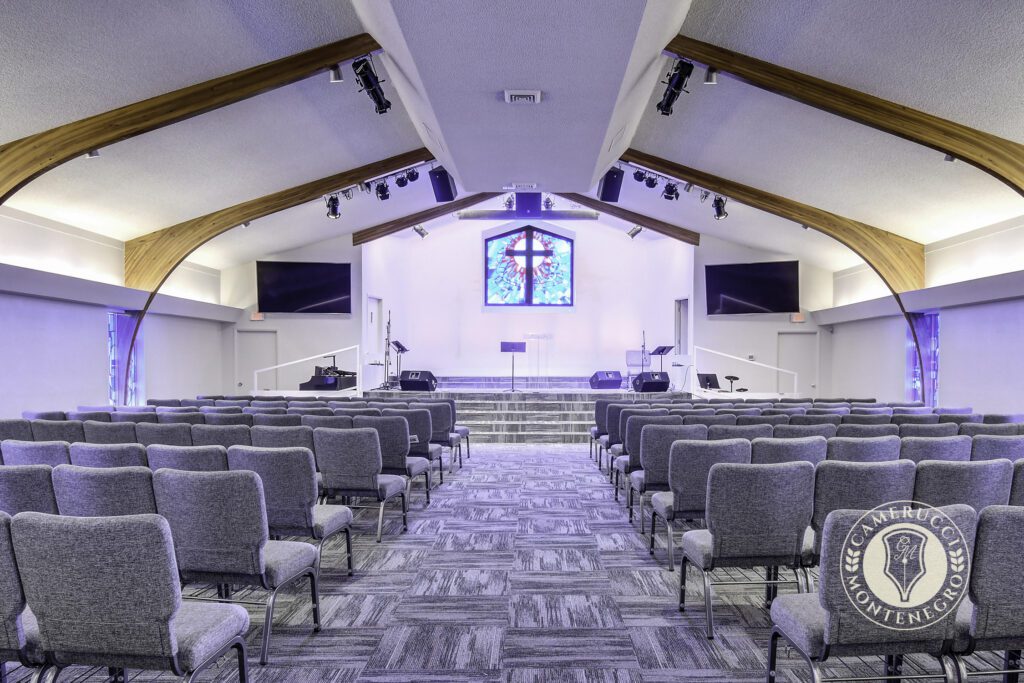 A church with many chairs and a cross on the wall