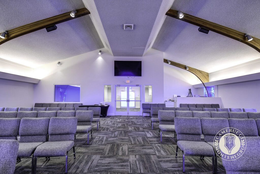 A room with many chairs and a large screen